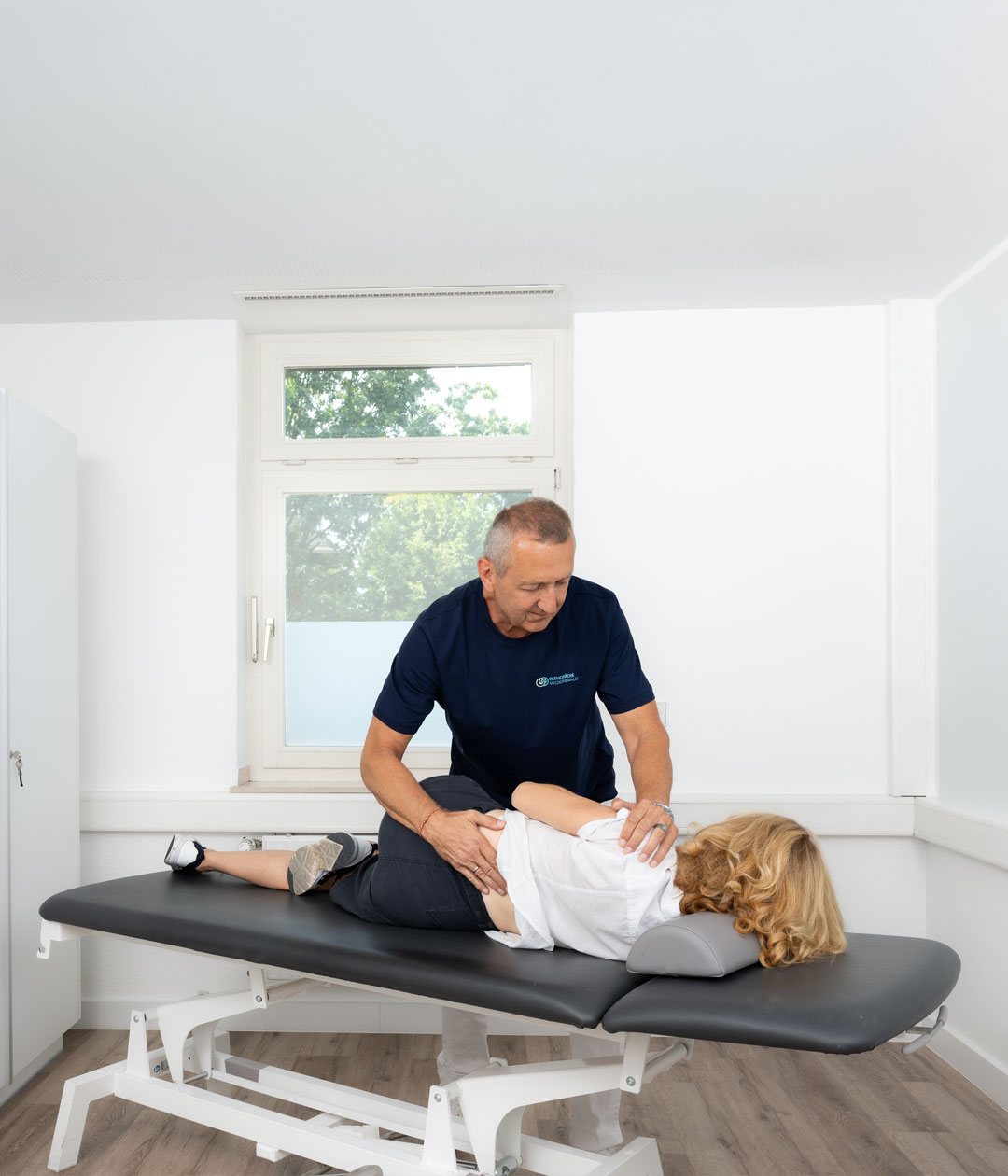 Dr. med. Thomas Fröhlich bei der manualmedizinischen Behandlung einer Patientin in der Praxis Orthopädie am Grünewald